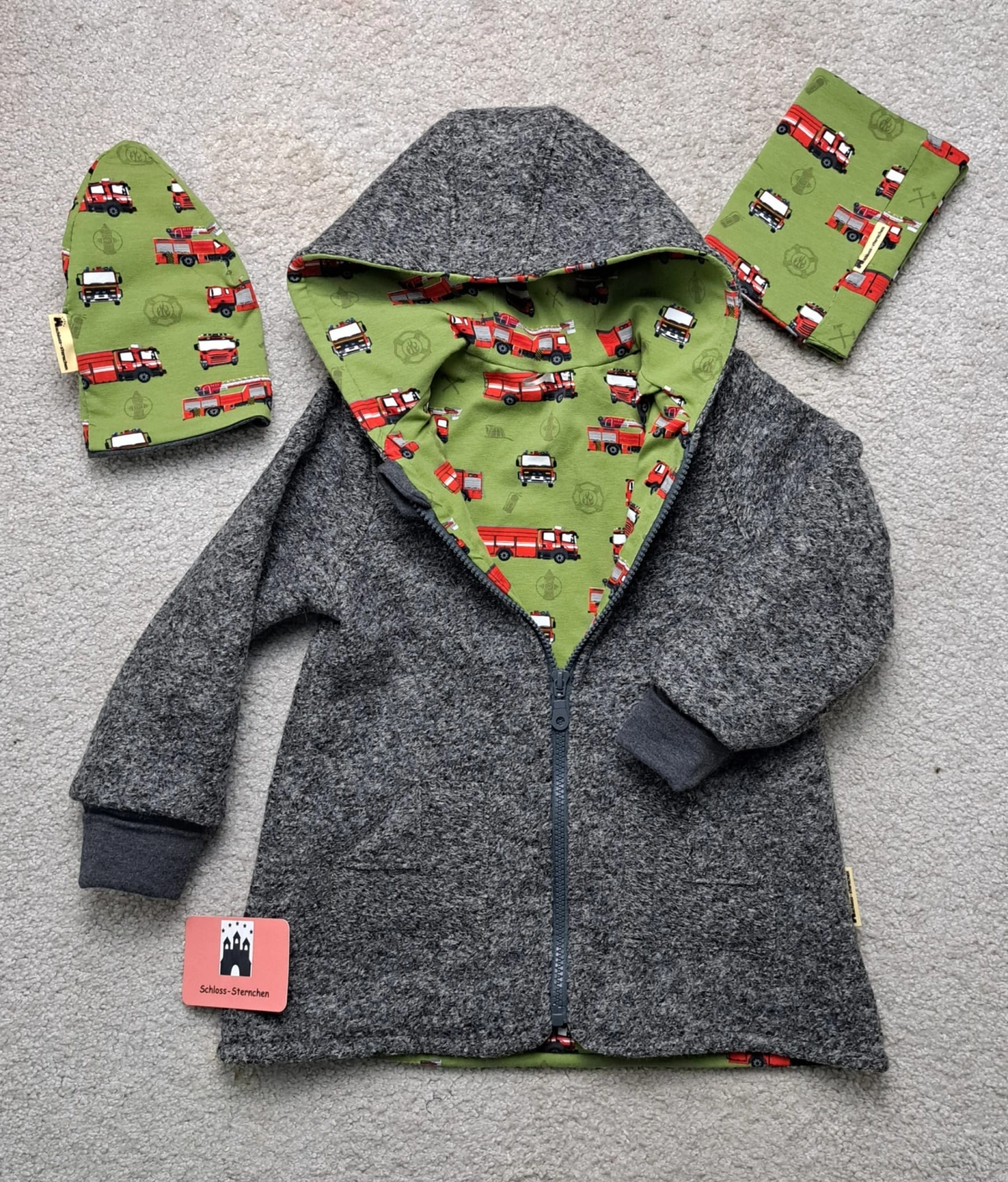 Walkjacke in Dunkelgrau mit Kapuze, grünem Feuerwehr-Innenfutter, passender Mütze und Halstuch